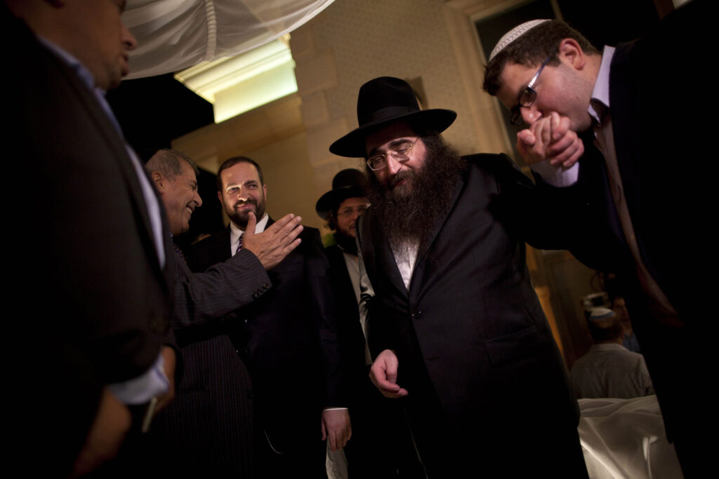In this July 11, 2011 file photo, a man kisses the hand of Rabbi Yoshiyahu Pinto at a wedding in Lod, central Israel.  In the fall of 2009, when future U.S. Rep. Michael Grimm announced his run for congress, he sorely needed a rainmaker who could get the dollars flowing to his nascent campaign. He found one in an Israeli Rabbi Pinto, but now that fruitful association has turned into a big headache for the Staten Island Republican - one involving allegations of illegal donations, a bizarre blackmail claim and potentially embarrassing associations with people in the pornography business. (AP Photo/Oded Balilty, File)